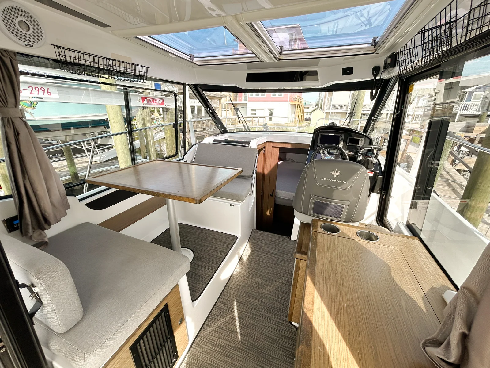 Bright pilothouse of EZ Livin with salon seating, galley and panoramic windows